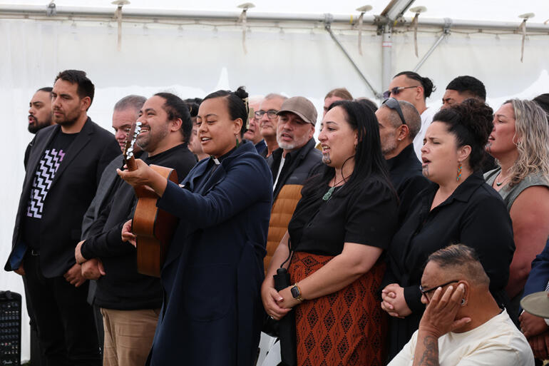 Tai Tokerau-based Evangelist the Reverend Keri-Ann Hokianga accompanies waiata on her guitar.