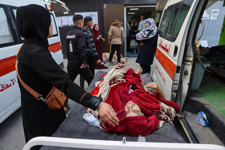 A woman waits next to her relative injured in an Israeli strike, at Al-Ahli Arab hospital in Gaza 18 March 2025. Photo: Omar Al Qattaa/Getty.