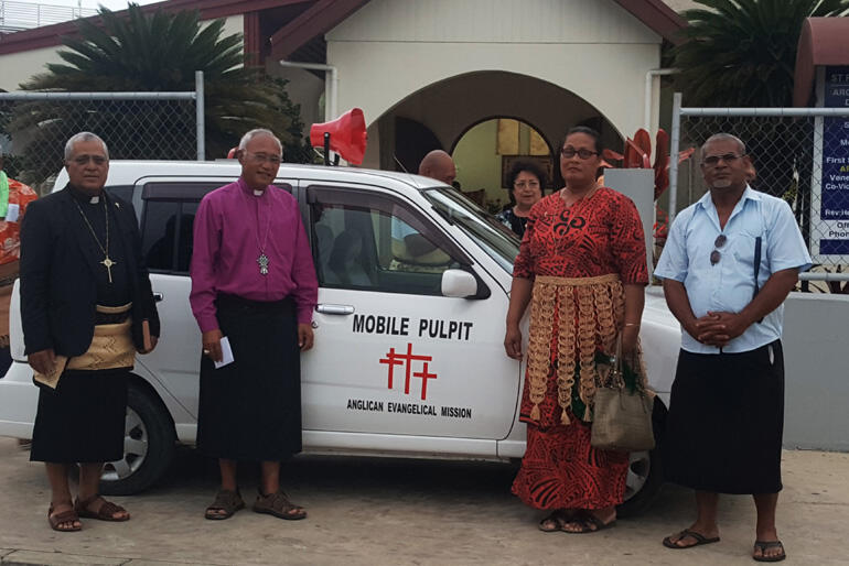Bishop 'Afa Vaka (L) shows off his mobile pulpit van during a visit from Archbishop Winston Halapua.