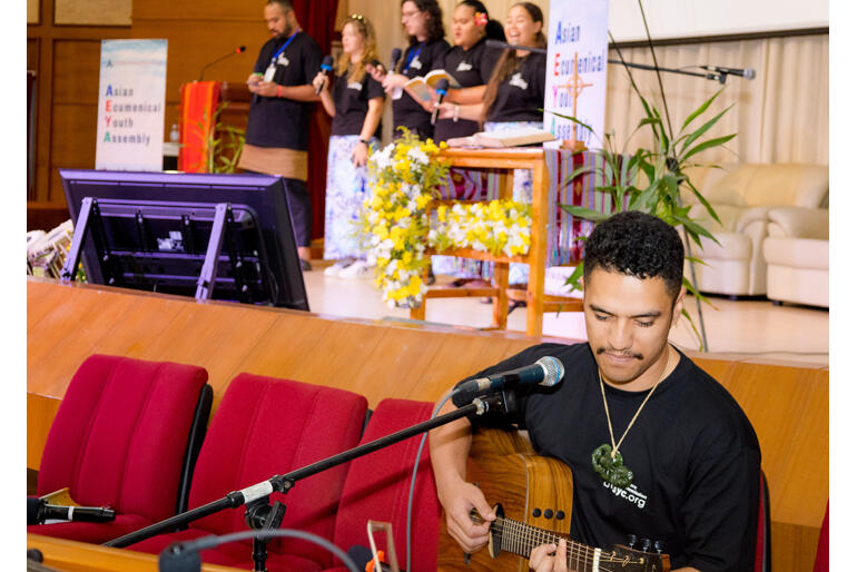 Kauri Tangohau plays guitar as the team leads waiata.